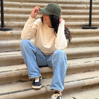 Vista trasera de la gorra KUMI en azul marino, con el bordado “OUTSTANDING PEOPLE CLUB” y cierre ajustable de tela con hebilla metálica