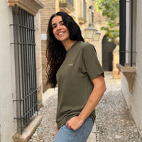 Modelo con Camiseta KUMI verde oliva de algodón orgánico, corte regular, en entorno mediterráneo