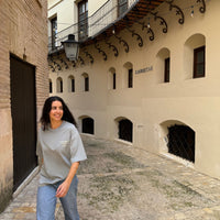 Modelo con la OPC Oversize T-Shirt gris caminando por una calle mediterránea