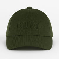 Gorra KUMI en color verde oliva vista de frente, con bordado tono sobre tono de “KUMI” sobre tejido de pana orgánica