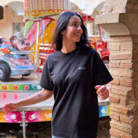 Modelo con Camiseta KUMI negra de algodón orgánico, corte regular, en ambiente urbano