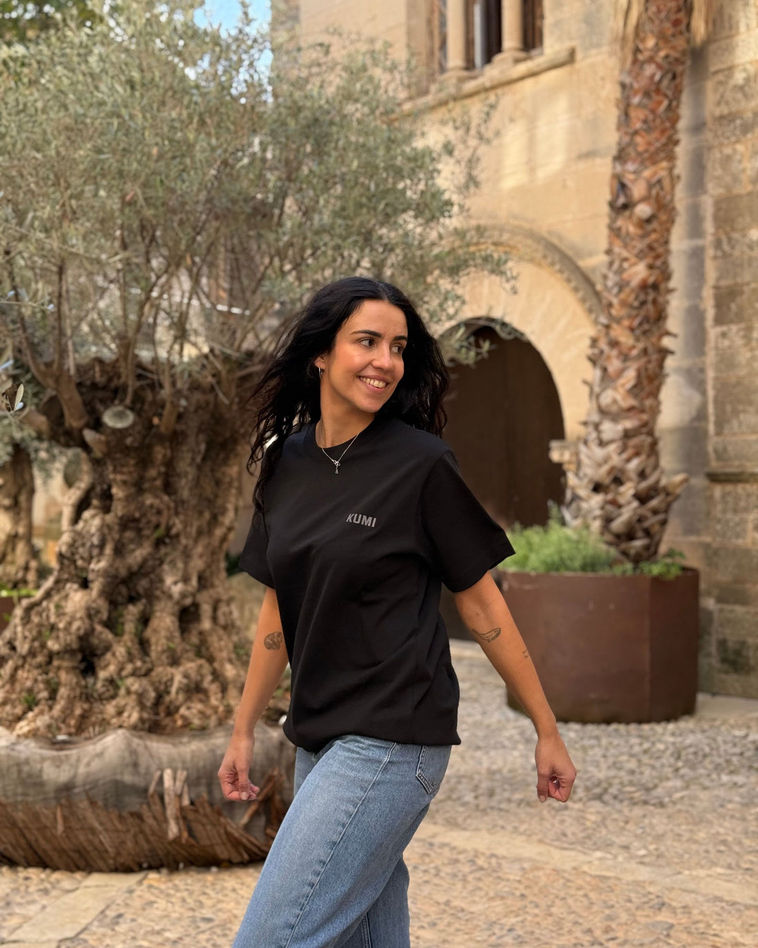 Camiseta KUMI negra de algodón orgánico, corte regular, en look casual al aire libre