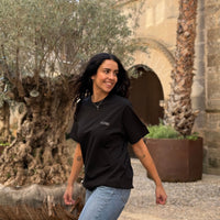 Camiseta KUMI negra de algodón orgánico, corte regular, en look casual al aire libre